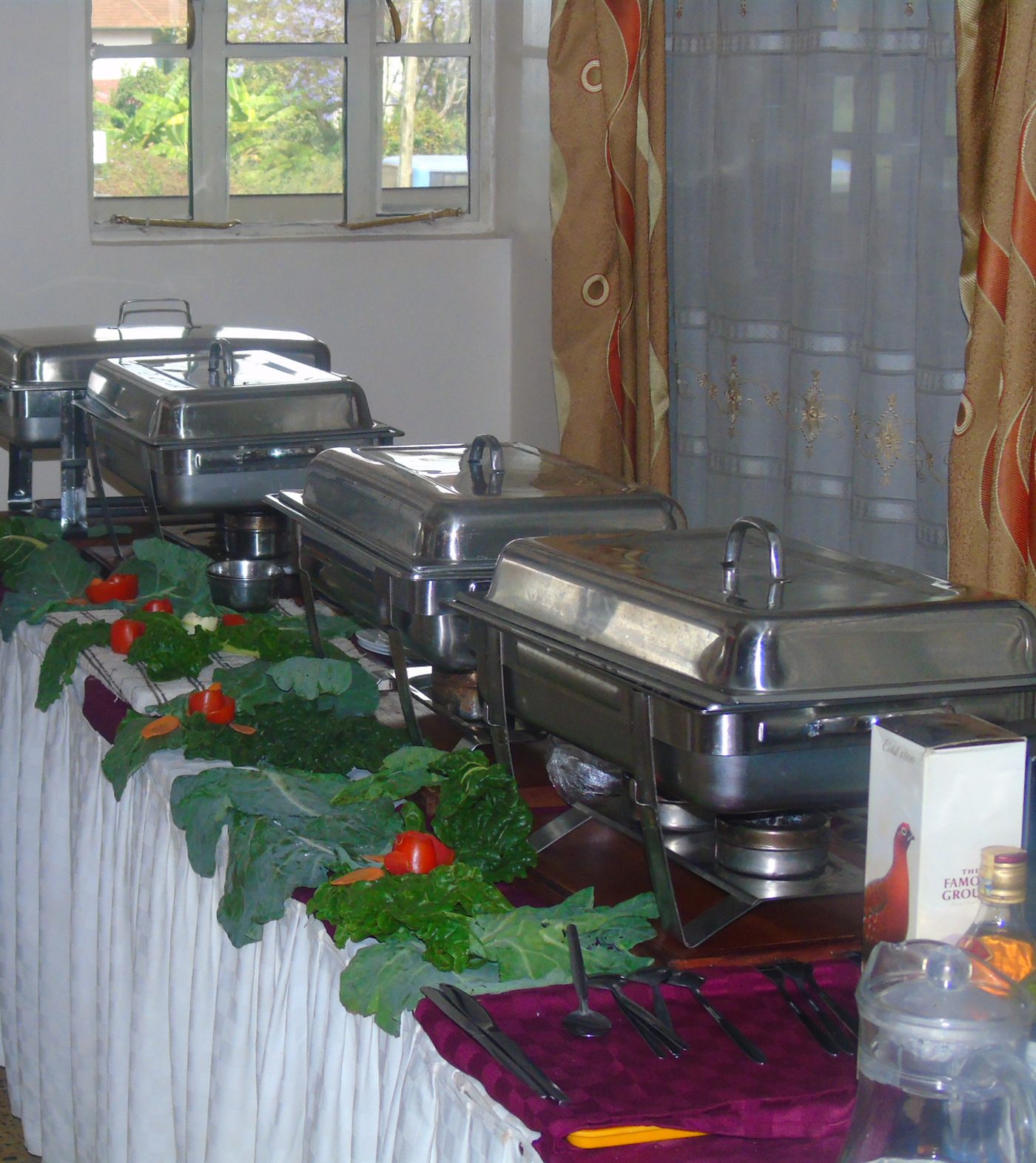 Buffet line of chafing dishes with fresh garnish